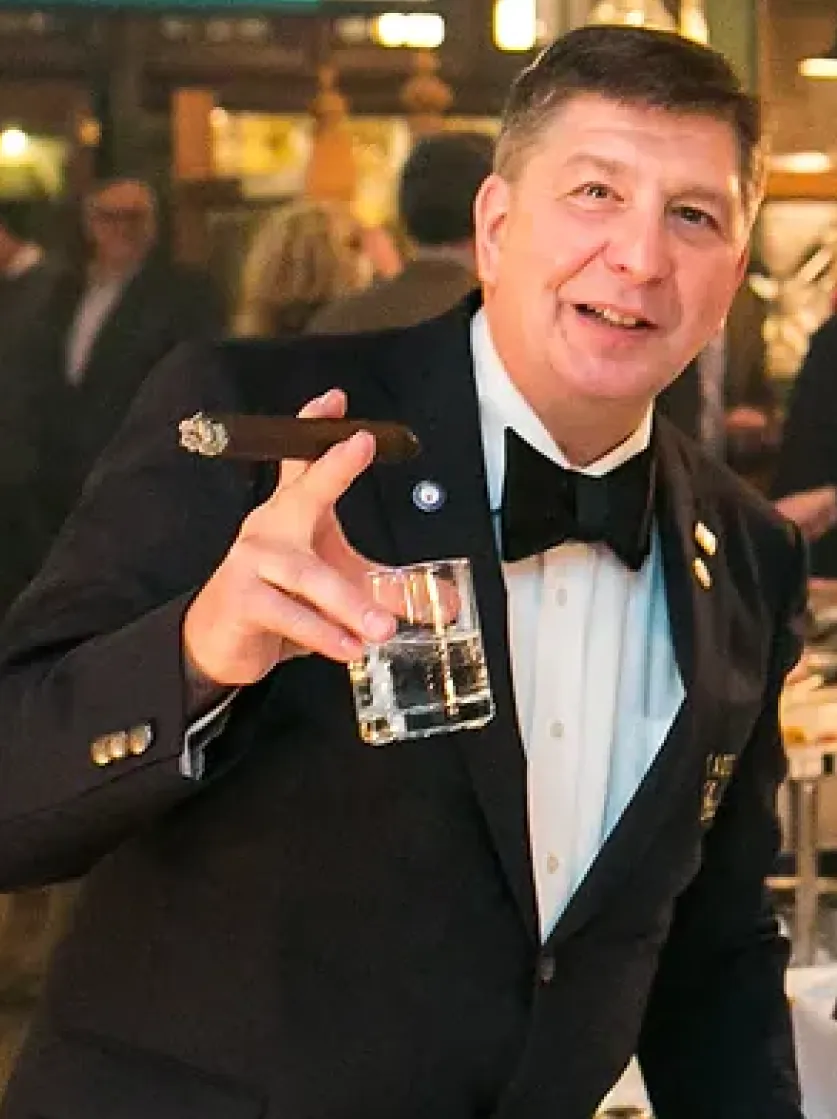 A past Aficionado in his tuxedo raising a glass at Taste the Good Life