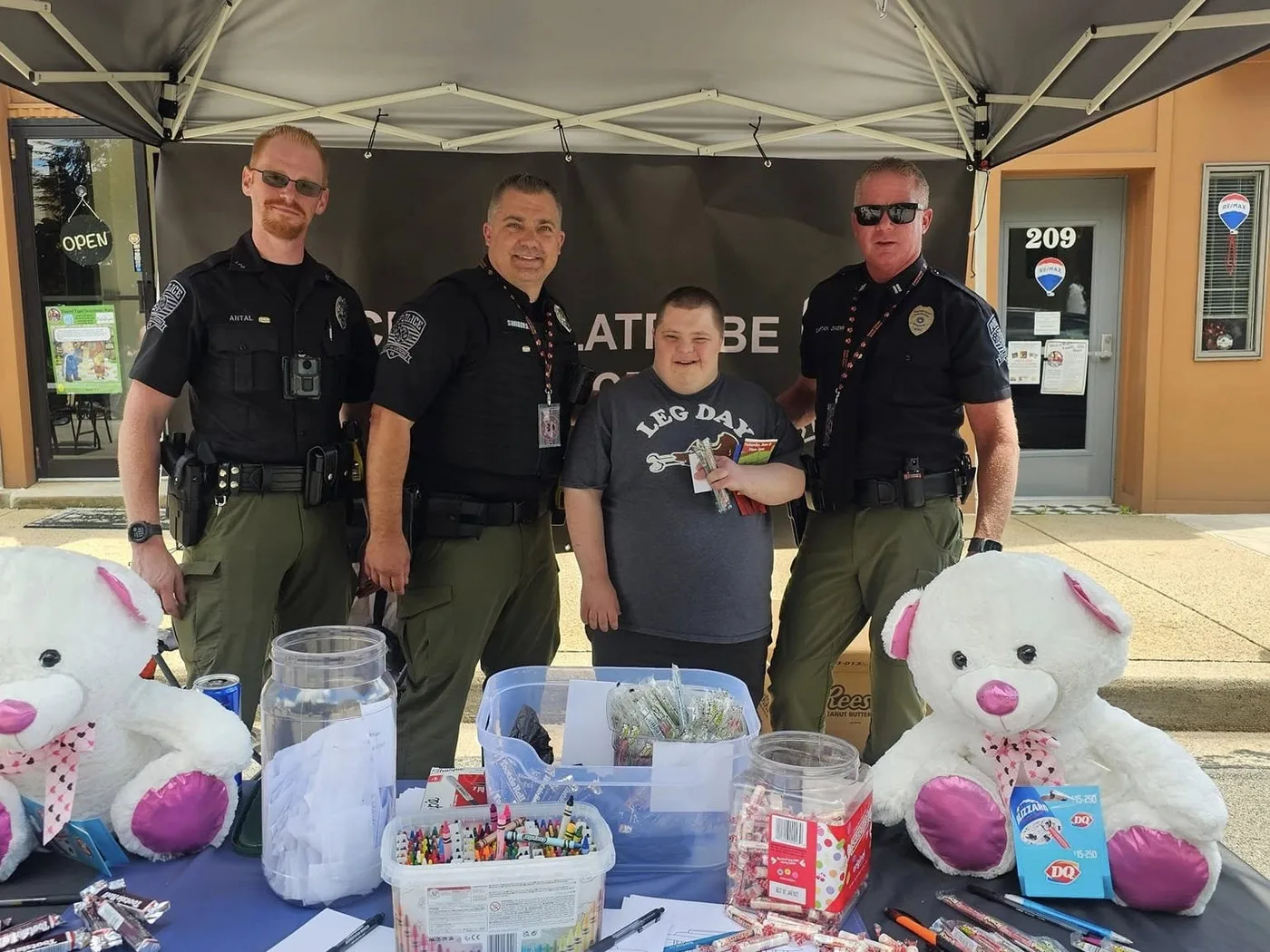 City of Latrobe police officers with a child at a community giveaway table